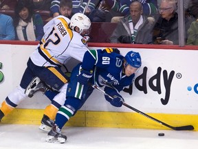 Nashville Predators centre Mike Fisher (12) fights for control of the puck with Vancouver Canucks centre Markus Granlund (60) during NHL action in Vancouver Saturday, March 12, 2016. (THE CANADIAN PRESS/Jonathan Hayward)