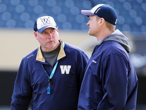 Winnipeg Blue Bombers offensive coordinator Paul LaPolice (l) and head coach Mike O'Shea confer during a mini camp in Winnipeg, Man. Monday April 25, 2016.