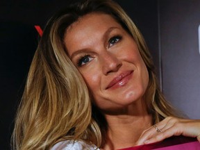 Brazilian model Gisele Bundchen poses for pictures with her book, titled Gisele Bundchen, dedicated her 20-year modeling career, prior to signing autographs in Sao Paulo, Brazil, Friday, Nov. 6, 2015. (AP Photo/Andre Penner)