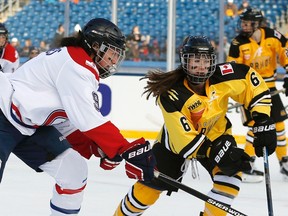 Montreal Les Canadiennes' Kim Deschenes (left) battles Boston Pride's Shannon Doyle for the puck during a women's outdoor hockey game ahead of the NHL Winter Classic at Gillette Stadium in Foxborough, Mass., on Dec. 31, 2015. (Michael Dwyer/AP Photo)