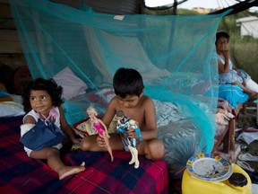 Kiara Farias, 2, whose arm was broken during the 7.8-magnitude earthquake, plays with her brother Jostin, 6, in a makeshift camp for people displaced by the quake, in Pedernales, Ecuador, Monday, April 25, 2016. (AP Photo/Rodrigo Abd)