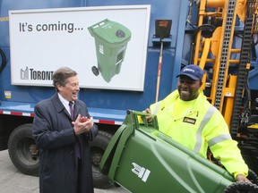 City worker Chris Vaughan demonstrates the new green bin to Toronto Mayor John Tory in front of an automated  waste disposal truck  on Thursday April 28, 2016. The mayor, councillors and waste management city workers demonstrated the new green bin's animal-resistant qualities and automated collection features.Veronica Henri/Toronto Sun/Postmedia Network