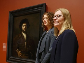Jan Allen, director of the Agnes Etherington Art Centre at Queen's University, right, and Jacquelyn Coutre, curator of the Bader Collection, stand with the gallery's newest addition, Rembrandt van Rijn's 1658 painting Portrait of a Man with Arms Akimbo on Thursday in Kingston. The masterpiece, donated late last year by Alfred and Isabel Bader, is to be unveiled Friday at the gallery's spring and summer season launch. (Elliot Ferguson/The Whig-Standard/Postmedia Network