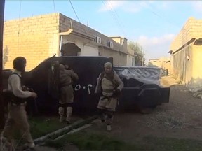 A man in an armoured vehicle, said to be a suicide bomber about to go out on a mission, talks to other Islamic State fighters in Iraq, in this still image taken from an amateur video supplied by Kurdish Peshmerga and received by Reuters on April 29, 2016.  Amateur video/via REUTERS TV