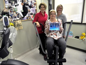 011, 022: Organ transplant recipient Ellen Desrosiers (centre) is flanked by physiotherapists Nancy Howes (left) and Tracey Fuller while holding an iPad on an exercise machine in London Ont. April 26, 2016. Fuller and Howes are offering physiotherapy to patients in the London Health Sciences Centre’s Multi-Organ Transplant Program via video conferencing, a first in Canada. CHRIS MONTANINI\LONDONER\POSTMEDIA NETWORK