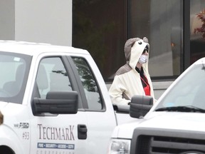 A man identified as Alex Brizzi wearing a full animal costume and surgical mask walks out of a TV station in Baltimore, Thursday, April 28, 2016. Baltimore police say a department sniper shot the man, who police say walked into a TV station displaying what appeared to be an explosive device on his chest. (Kenneth K. Lam/The Baltimore Sun via AP)