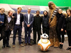 (L-R) Mark Hamill, director Rian Johnson, Prince Harry, Prince William, Duke of Cambridge, British actor John Boyega, Chewbacca and British actress Daisy Ridley pose during a tour of the Star Wars sets at Pinewood studios in Iver Heath, west of London, Britain on April 19, 2016. REUTERS/Adrian Dennis/Pool