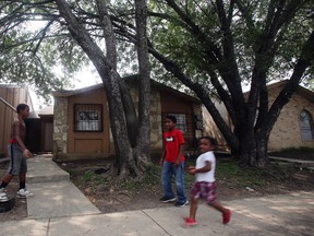 Kids play Friday April 29, 2016 in front of the townhouse at 8105 Chipping in San Antonio, Texas, where children were allegedly chained up in the back yard. Authorities say they have arrested a woman who is the mother of six of eight children who were found unsupervised in the middle of the night at a San Antonio home. A spokesman for the Bexar County sheriff's office says the 34-year-old woman also was supposed to be looking after two other children who were found tied up in the backyard. (John Davenport/The San Antonio Express-News via AP)