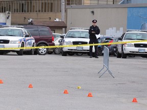 A line of police cruisers sits near the scene of an early morning shooting in a parking lot attached to The CEEPS and Barney?s Bar and Grill. One man remains in critical condition after a shooting about 2:20 a.m. behind a home at 200 John St., a parking lot connected to the bar lots. (CRAIG GLOVER, The London Free Press)