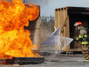 Quincy Emmons, FireRein president and CEO, demonstrates how quickly the company's new gel additive, Eco-Gel, can put out a heptane fire and not re-ignite during a demonstration at the Loyalist Township Emergency Services Fire Training Centre in Odessa on Friday. Students from St. Lawrence College competed scientific testing comparing the Eco-Gel to standard water and other fire suppression products on the market. (Julia McKay/The Whig-Standard)