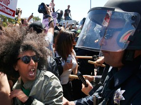 Biseat Yawkal, an Oakland protester, yells as she is pushed by police trying to push protesters back outside of the Hyatt Regency during the first day of the California Republican Party Convention in Burlingame, Calif., Thursday, April 29, 2016. The convention featured speeches from Presidential candidates Donald Trump and John Kasich among others. (Leah Millis/San Francisco Chronicle via AP)