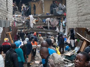 People help survivors retrieve their household items at the site of a building collapse in Nairobi, Kenya, Saturday, April 30, 2016. A six-story residential building in a low income area of the Kenyan capital collapsed Friday night under heavy rain and flooding, killing at least seven people and injuring over 100 others, Kenyan officials said. (AP Photo/Sayyid Abdul Azim)