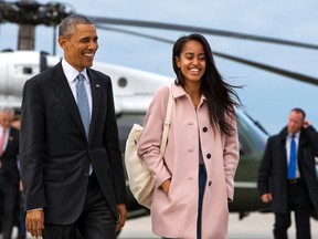 FILE - In a Thursday, April 7, 2016 file photo, President Barack Obama jokes with his daughter Malia Obama as they walk to board Air Force One from the Marine One helicopter, as they leave Chicago en route to Los Angeles.  The White House announced Sunday, May 1, 2016, that Malia Obama will take a year off after high school and attend Harvard University in 2017. (AP Photo/Jacquelyn Martin, File)