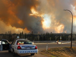 RCMP set up a blockade across from Mackenzie Blvd. on Highway 63, as smoke from a forest fire south of Fort McMurray starts to cover the valley. (Stephanie Jellett/ Fort McMurray Today/ Postmedia Network)
