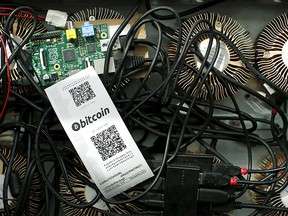 A bitcoin mining machine and a paper wallet with QR codes are seen in an illustration picture taken at La Maison du Bitcoin in Paris in this July 11, 2014 file photo.  REUTERS/Benoit Tessier/Files