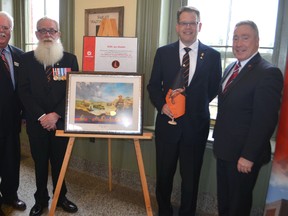 Fanshawe College St. Thomas-Elgin Regional Campus chair Ross Fair, left, Kangaroos veterans association members Mark Tonner and Bill Miller and Fanshawe College president Peter Devlin celebrate a $20,000 contribution to the Kangaroo Regiment Award Thursday evening. Miller's father, Trooper William Miller, a member of the regiment, passed away 10 months ago. His family decided to donate some of his estate to support the welding program award at the local campus.