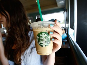 A patron holds an iced beverage at a Starbucks coffee store in Pasadena, Calif., July 25, 2013.  REUTERS FILE PHOTO/Mario Anzuoni