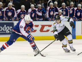 Windsor Spitfires forward Luke Boka (left) takes possession of the puck away from London Knights forward Sam Miletic (right) during OHL action in London, Ont. on Dec. 4, 2015. The Spitfires will host the Memorial Cup in 2017. (Craig Glover/Postmedia Network)