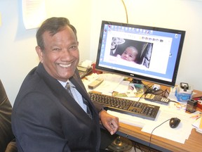 A photo of his grandchild on his own computer, Sam Laldin sits at his desk at his home in Kingston. He operates a basic computer literacy program for seniors. (Michael Lea/The Whig-Standard)