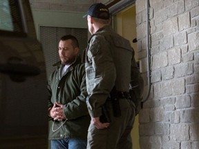 O.P.P. officers escort Rock Machine boss Jean-Francois Emard out of the courthouse in L'Orignal, Ontario following his bail hearing on Monday May 2, 2016. Postmedia Photo