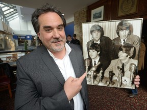 Paul Rivard, director of the London Beatles Festival, poses with a photo of the Fab Four. (Free Press file photo)