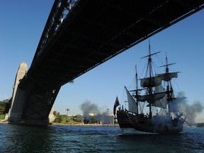 The Endeavour replica ship, centre, fires a canon as she sails under the Sydney Harbour Bridge on May 21, 2012. Researchers believe they have found the HMS Endeavour, the ship that legendary explorer Captain James Cook used to sail around the world, submerged somewhere in Rhode Island's Newport Harbor. (AFP PHOTO/Greg Wood)