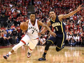 Raptors guard Kyle Lowry (left) dribbles past Pacers guard George Hill (right) during the fourth quarter of Game 7 of their first round NBA playoff series in Toronto on Sunday, May 1, 2016. (Dan Hamilton/USA TODAY Sports)
