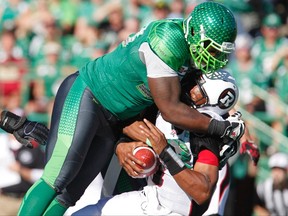Redblacks quarterback Henry Burris (right) gets tackled hard by Roughriders defensive tackle Tearrius George during CFL action in Regina on Sept. 21, 2014. (David Stobbe/Reuters/Files)
