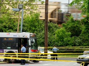 Police work a crime scene after authorities say a man attacked a bus driver, stole the bus, then struck and killed a man after the bus jumped a curb at a gas station at the corner of Helen Burroughs Avenue and Minnesota Avenue in Northwest Washington, Tuesday, May 3, 2016. (AP Photo/Andrew Harnik)