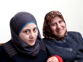 Ayat Al Khalaf, left, holds her son, Ahmad, who was born on Monday beside grandmother Turkiya in their Kingston home on Tuesday. Ahmad is believed to be the first Syrian baby born in Kingston. (Ian MacAlpine/The Whig-Standard)