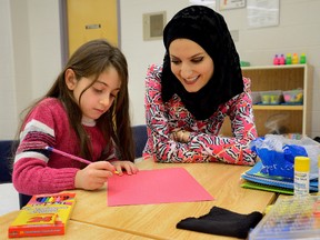 Daniella Toma, 8, works with teacher Najwa Zebian at the Gentle family reception centre set up for new refugees at White Oaks Public School on Tuesday Jan 5, 2016. (MORRIS LAMONT, Free Press file photo)