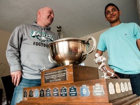 Nepean Eagles coach Jarred Desjardins (left) and Eagles player Adam Diwani get up close and personal with the Governor-General Roland Michener Trophy. (Errol McGihon/Ottawa Sun)