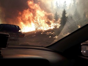 Wildfires near Highway 63 southbound as residents of Fort McMurray leave the downtown area on Tuesday May 3, 2016. Robert Murray/Fort McMurray Today/Postmedia Network