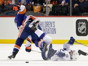 Tampa Bay Lightning left winger Jonathan Drouin is knocked to the ice by New York Islanders defenceman Thomas Hickey during the second period of Game 3 of an NHL playoff series in New York on May 3, 2016. (AP Photo/Frank Franklin II)