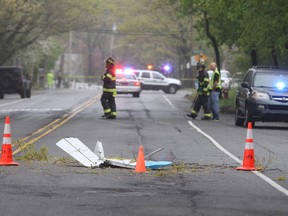 Traffic cones mark the position of pieces from a Beech BE-35 light plane after the aircraft crashed in a residential neighborhood in Syosset, N.Y., Tuesday, May 3, 2016. A spokesman for the Federal Aviation Administration said that the plane that had taken off from Myrtle Beach, S.C. and was headed to Robertson Field, an airport in Plainville, Conn. All three aboard the plane died in the crash. (Howard Schnapp/Newsday via AP)