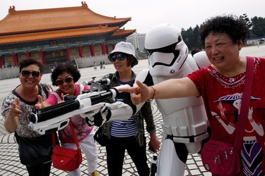 Tourists from China pose with a man dressed as a Storm Trooper from "Star Wars" during Star Wars Day in Taipei, Taiwan May 4, 2016. REUTERS/Tyrone Siu