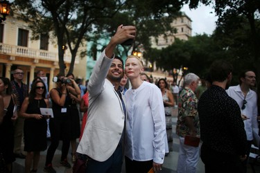 Actress Tilda Swinton (R) takes a picture with a guest prior to a fashion show displaying creations by German designer Karl Lagerfeld as part of his latest inter-seasonal Cruise collection for fashion house Chanel at the Paseo del Prado street in Havana, Cuba, May 3, 2016. REUTERS/Alexandre Meneghini