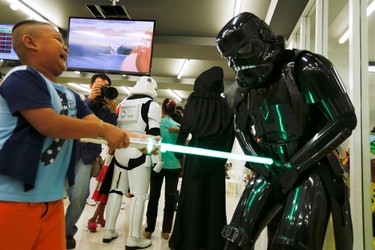 A member of a Star Wars fan club in Thailand, dressed as a Shadow stormtrooper plays with a boy during Star Wars Day celebration at the Queen Sirikit National Institute of Child Health in Bangkok, Thailand, May 4, 2016. REUTERS/Chaiwat Subprasom