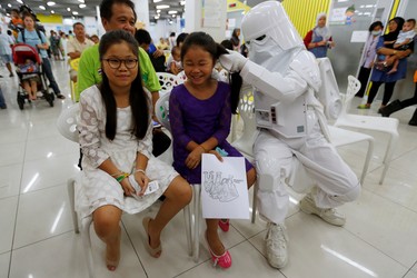 A member of a Star Wars fan club in Thailand, dressed as a Snowtrooper plays with children during Star Wars Day celebration at the Queen Sirikit National Institute of Child Health in Bangkok, Thailand, May 4, 2016. REUTERS/Chaiwat Subprasom