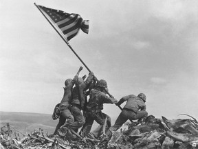 In this Feb. 23, 1945 file photo, U.S. Marines of the 28th Regiment, 5th Division, raise the American flag atop Mt. Suribachi, Iwo Jima, Japan. The Marine Corps said Monday, May 2, 2016, that it has begun investigating whether it mistakenly identified one of the men shown raising the U.S. flag at Iwo Jima in one of the iconic images of the Second World War after two amateur history buffs began raising questions about the picture. (AP Photo/Joe Rosenthal)