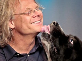 Colin Campbell and his best friend George, a once neglected and homeless 140-pound Newfoundland Landseer dog, show their closeness during an interview, Monday May 2, 2016, in New York.  Campbell is doing a nationwide promotional tour for his new book, “Free Days with George,” that documents the love story between a man and his dog.  (AP Photo/Bebeto Matthews)