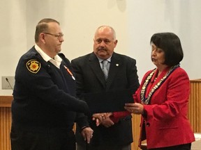 Retired Oil Springs Deputy Fire Chief Terry May was recognized for his bravery by Oil Springs Mayor Ian Veen and Lambton County Warden Bev MacDougall at Wednesday's county council meeting. May saved a woman's life by pulling her from her burning Petrolia home in early April. (Barbara Simpson, The Observer)