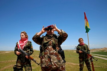 Iraqi Kurdish female fighter Haseba Nauzad looks through a pair of binoculars during a deployment near the frontline of the fight against Islamic State militants in Nawaran near Mosul, Iraq, April 20, 2016.  REUTERS/Ahmed Jadallah