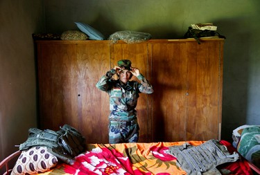 Yazidi female fighter Asema Dahir, 21, adjusts her cap inside a bedroom at a site near the frontline of the fight against Islamic State militants in Nawaran near Mosul, Iraq April 20, 2016.  REUTERS/Ahmed Jadallah