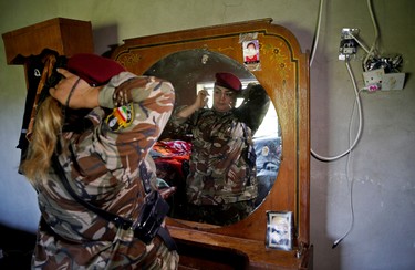 Iraqi Kurdish female fighter Haseba Nauzad, 24, looks at a mirror as she adjusts her clothes in a bedroom at a site near the frontline of the fight against Islamic State militants in Nawaran near Mosul, Iraq April 20, 2016.  REUTERS/Ahmed Jadallah
