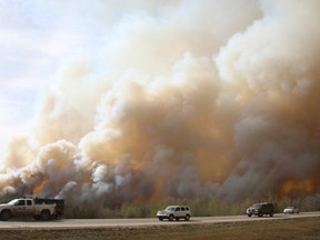 Residents of Fort McMurray flee southbound on Highway 63 Tuesday. Wildfires forced the evacuation of the city Tuesday as high temperatures and winds continued to batter the region. Robert Murray/Fort McMurray Today/Postmedia Network