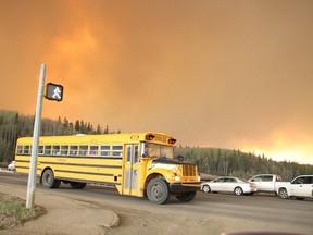 A school bus evacuating children from a school in the subdivision of Abasand drives through an intersection in Fort McMurray on Tuesday. (Robert Murray/Fort McMurray Today/Postmedia Network)