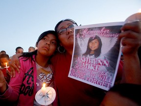 This Tuesday, May 4, 2016 photo Klandre Willie, left, and her mother, Jaycelyn Blackie, participate in a candlelight vigil,  for Ashlynne Mike at the San Juan Chapter House in Lower Fruitland, N.M. (Jon Austria/The Daily Times via AP)
