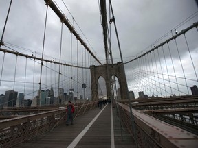Commuters make their way across the Brooklyn Bridge in the Brooklyn Borough of New York, November 2, 2012. REUTERS/Keith Bedford