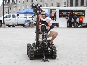 Brent Richard tries to reassure his daughter Elliot, 2, as the Kingsto Police robot approaches during Wednesday's emergency services display in Springer Market Square on May 4, 2016 in Kingston, Ont.
Elliot Ferguson/The Whig-Standard/Postmedia Network